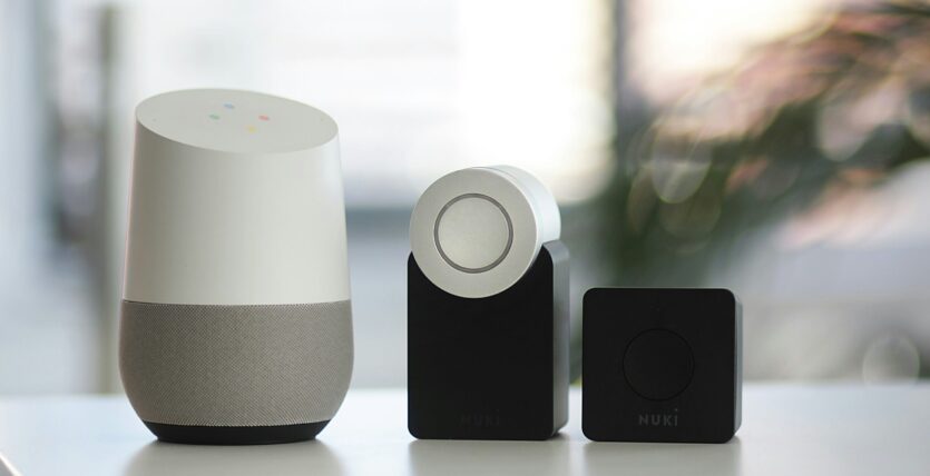 white and gray Google smart speaker and wo black speakers