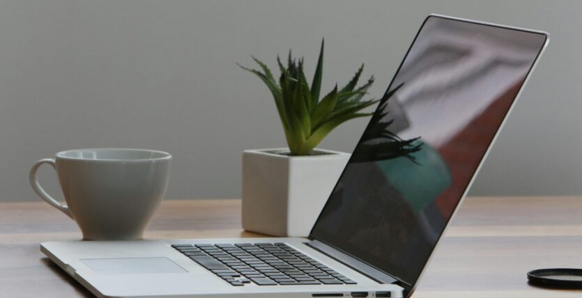 Free Minimalist home office desk with laptop, smartphone, and plant for a modern work environment. Stock Photo
