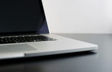 silver laptop computer on black table