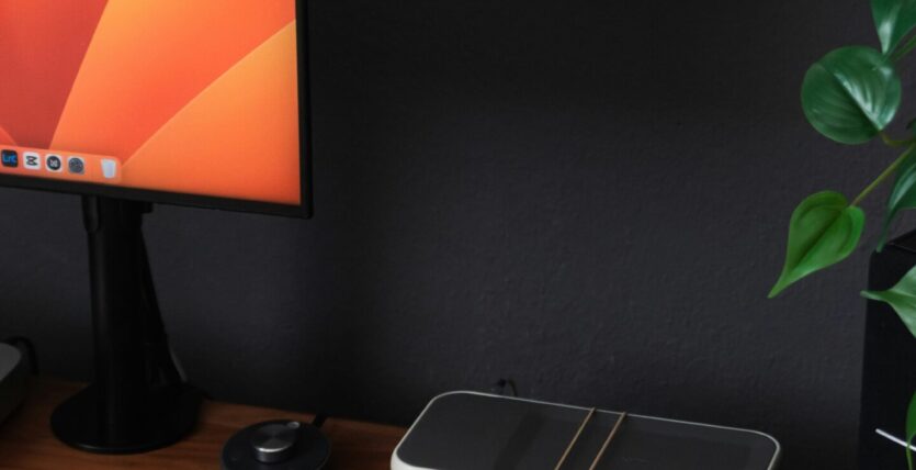 a desk with a laptop, keyboard, mouse and a monitor