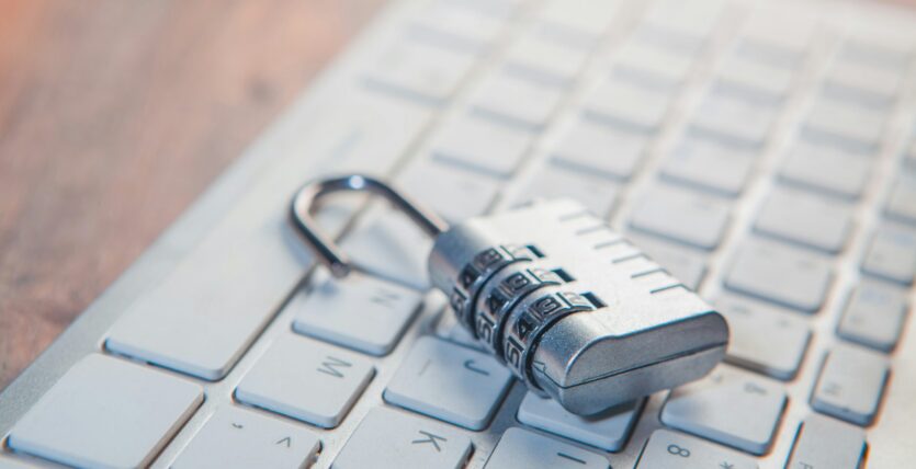 A combination lock rests on a computer keyboard.