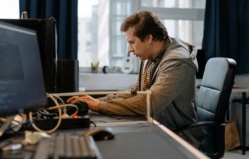 Free A concentrated professional working at a computer in a modern office setting. Stock Photo