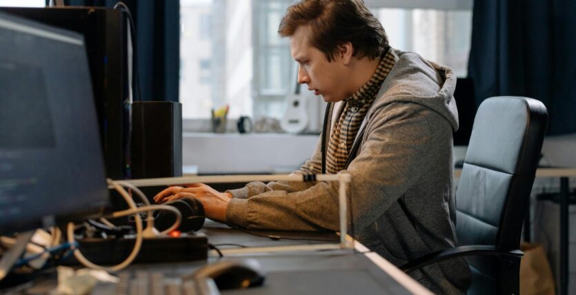 Free A concentrated professional working at a computer in a modern office setting. Stock Photo